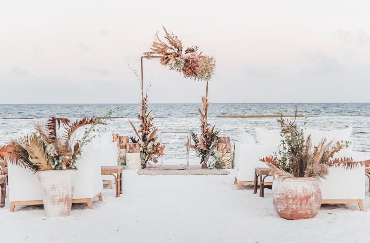 Boho beach wedding Mexico with pampas grass and salmon hues | PartySlate