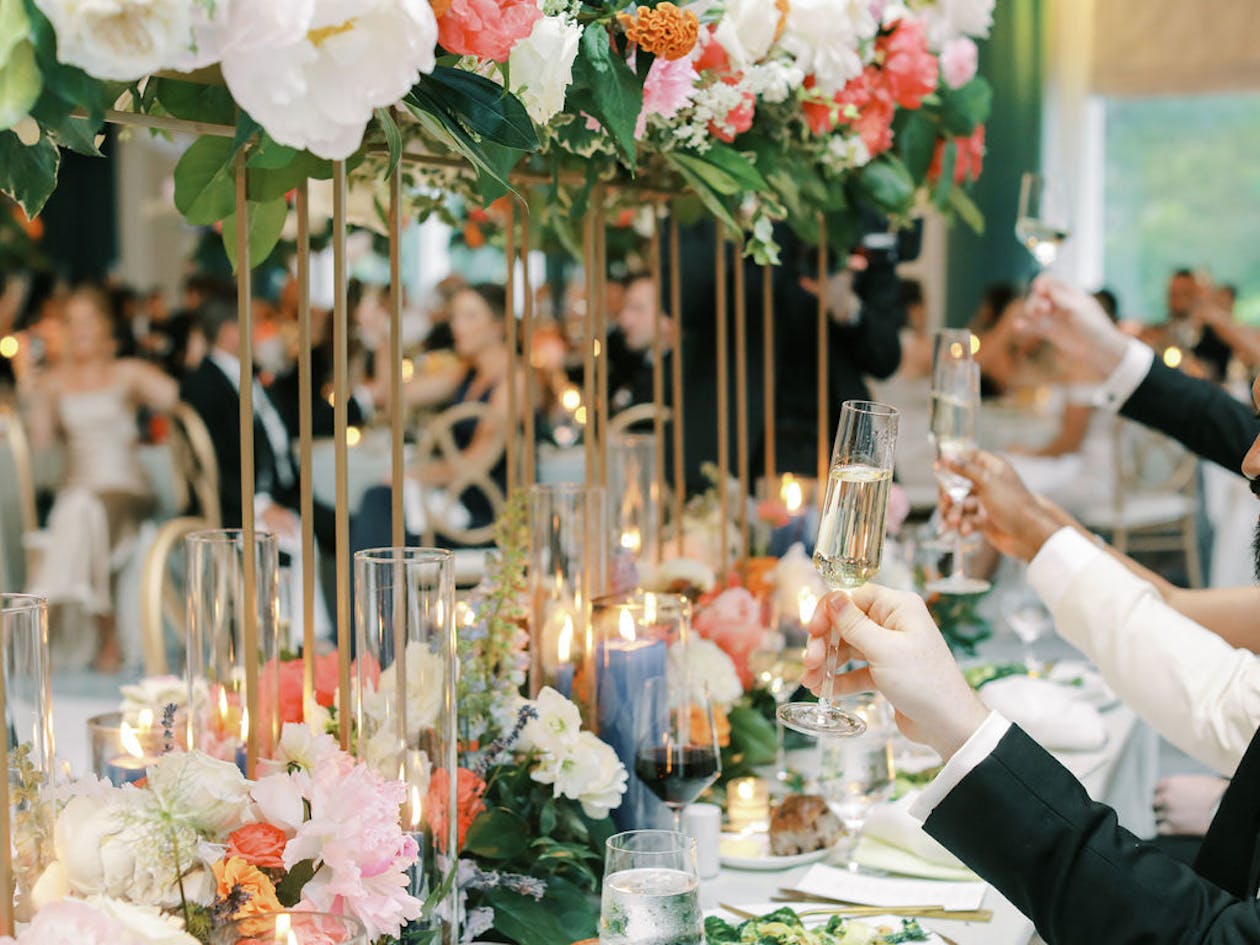 Elevated Colorful Wedding Centerpiece With Guests Raising A Glass for Toast | PartySlate