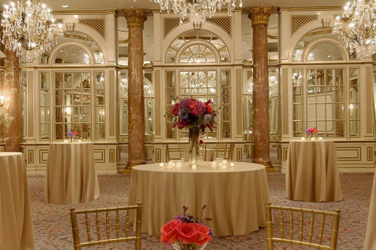 Luxury hotel ballroom wedding venue with gold accents on walls and in décor | PartySlate