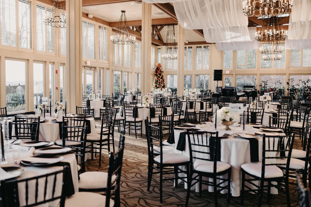black and white classic wedding theme with white florals and black chairs at each table | PartySlate