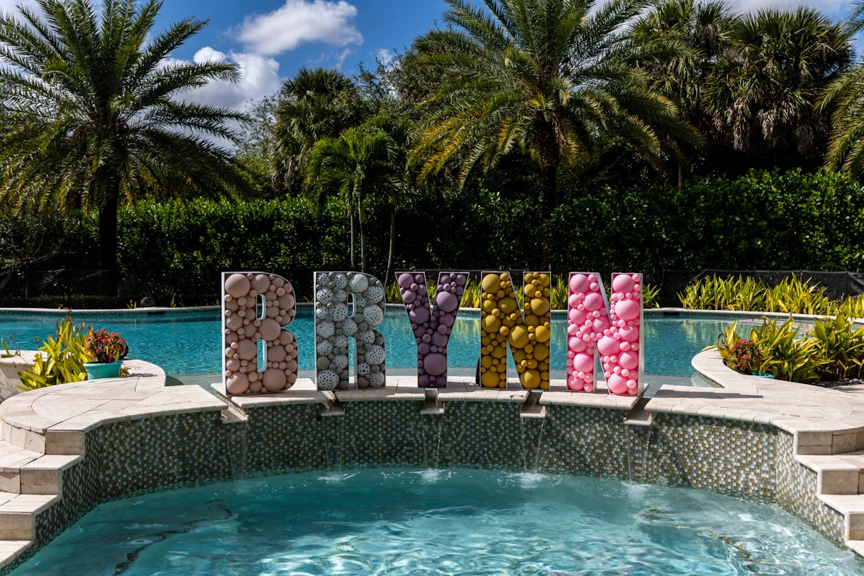 The name Brynn spelled out in a balloon sign by the edge of a pool at kids birthday party | PartySlate