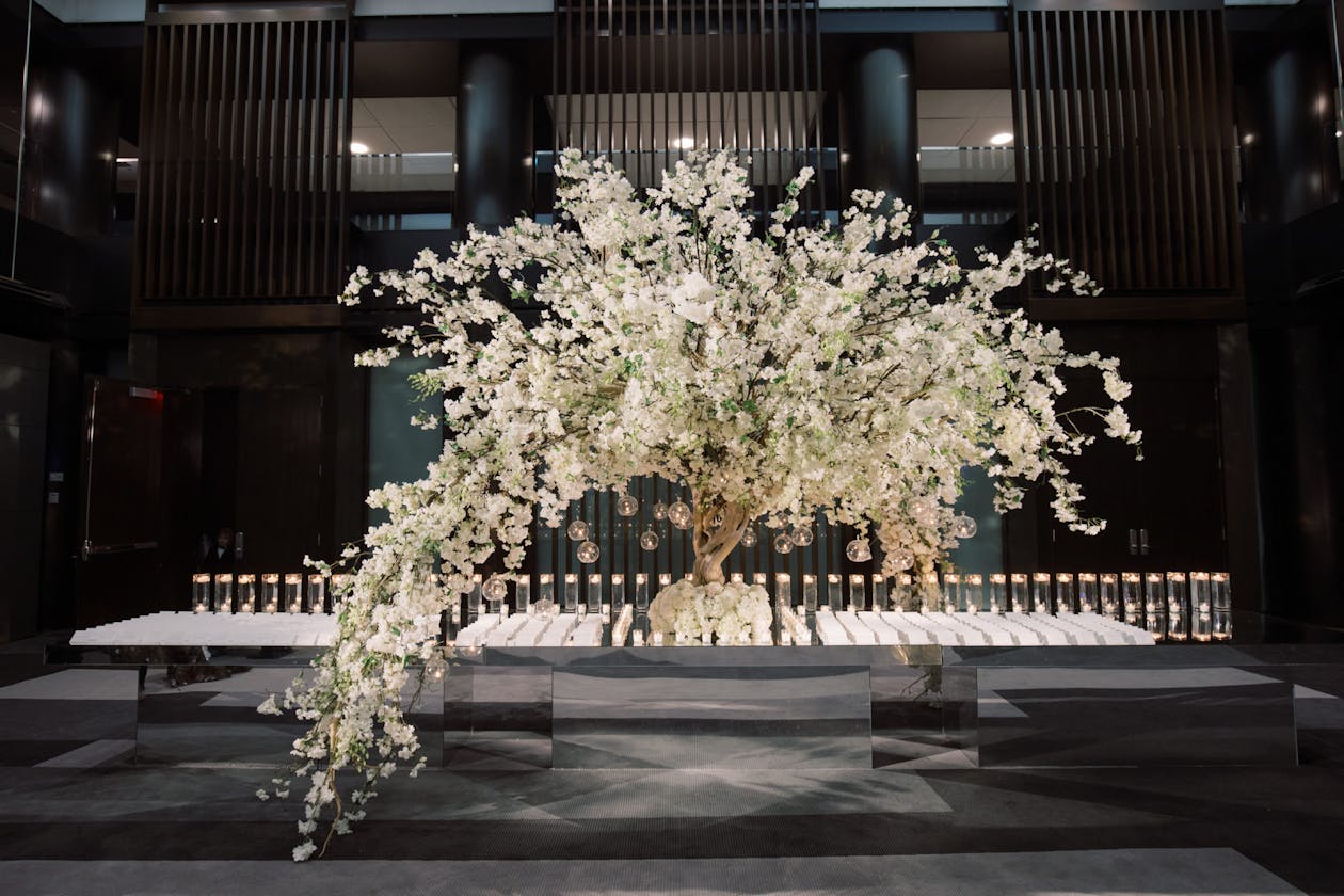 Wedding escort table with towering white floral tree as centerpiece | PartySlate