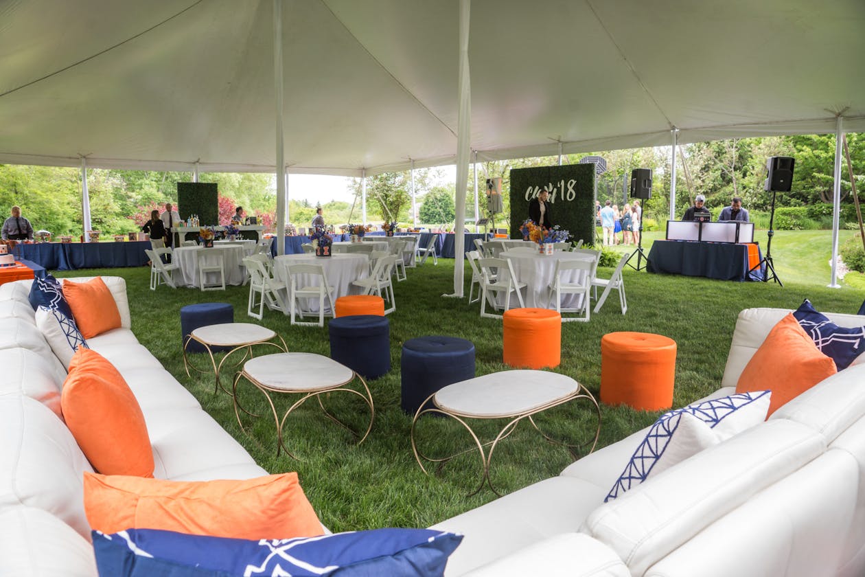 orange and blue graduation party with white couches and lounge area | PartySlate