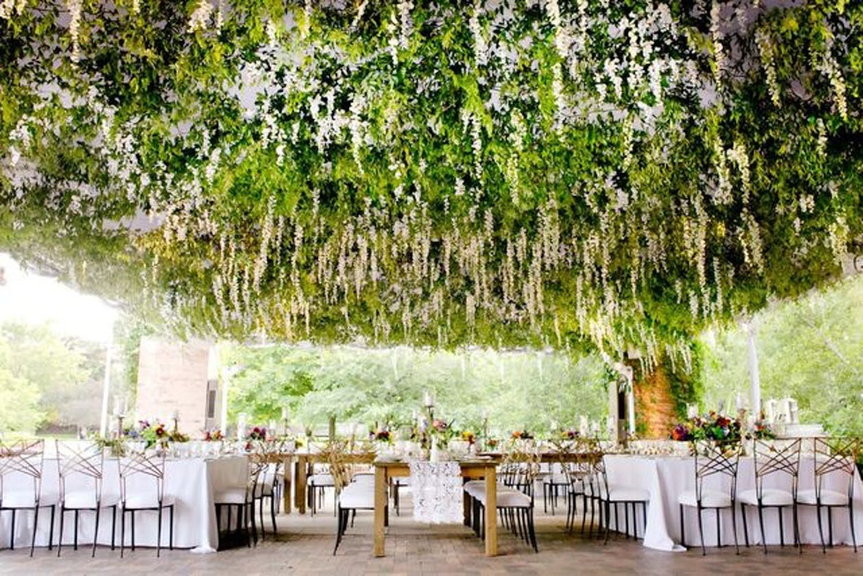 Wedding tent with suspended greenery from ceiling | PartySlate