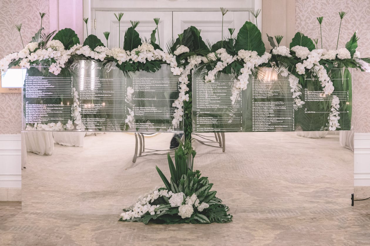 Tropical lucite wedding seating chart with monstera leaves | PartySlate