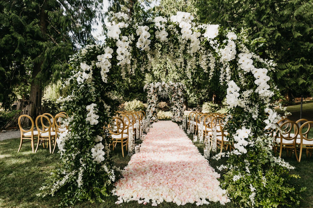 Double circular arches of greenery and white blooms at wedding | PartySlate