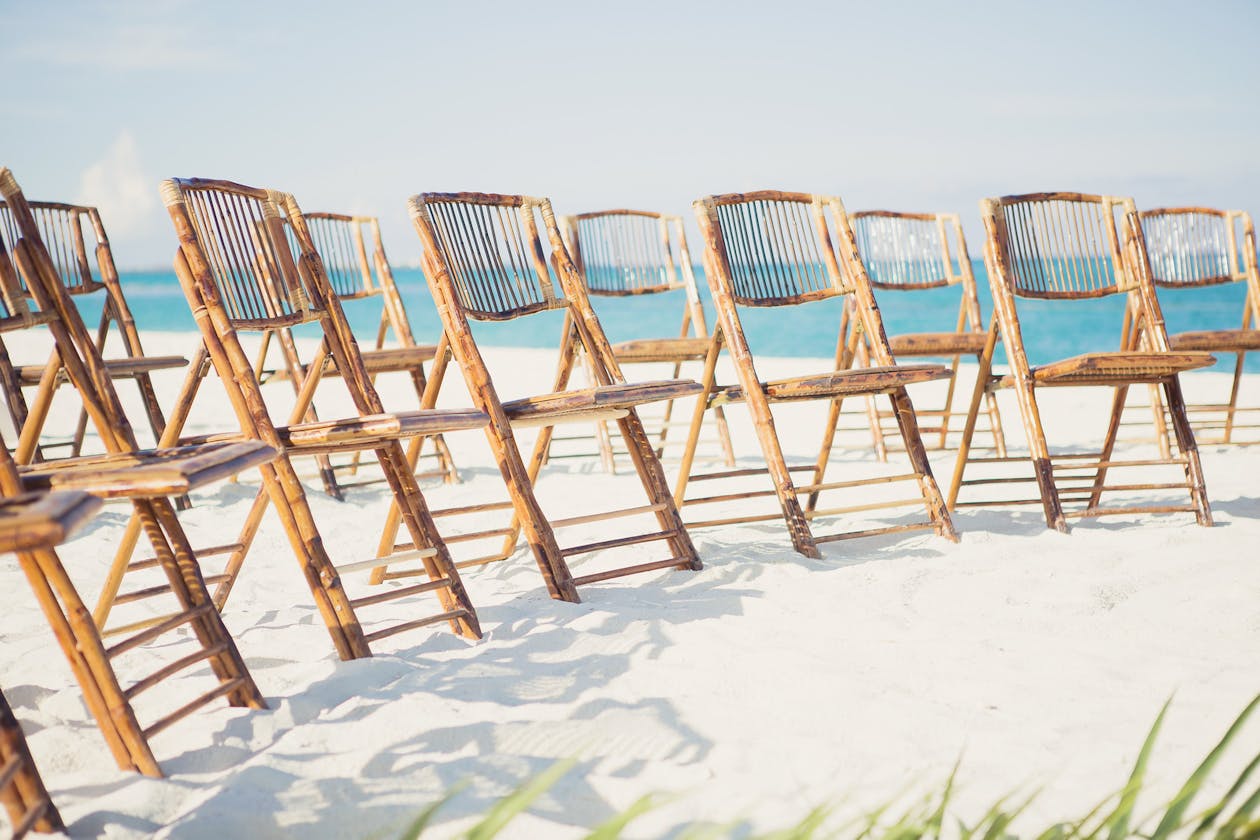 Rattan chairs for beach wedding ceremony | PartySlate