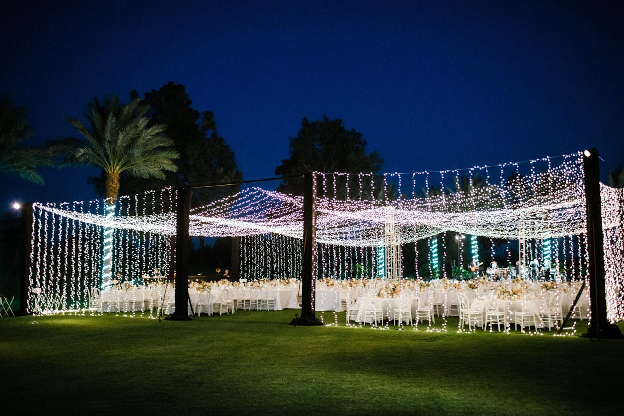 Outdoor wedding with string light tenting | PartySlate