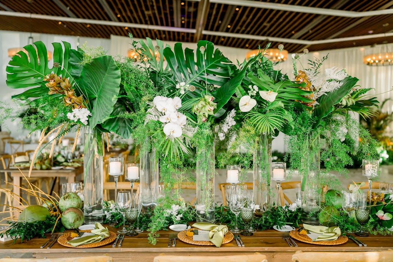 Monstera leaf with white orchid tropical wedding centerpieces | PartySlate