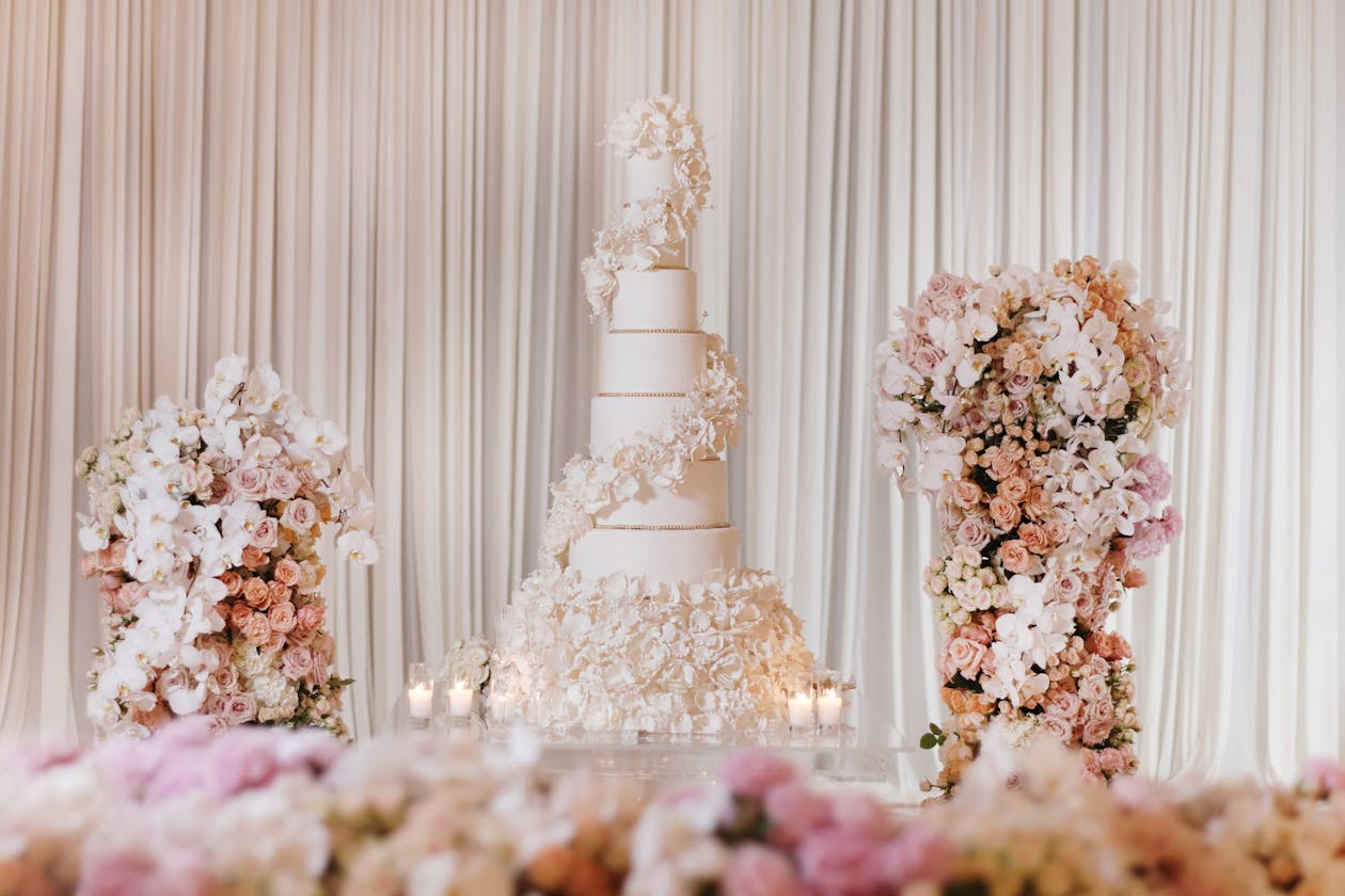 Towering white wedding cake with florals | PartySlate