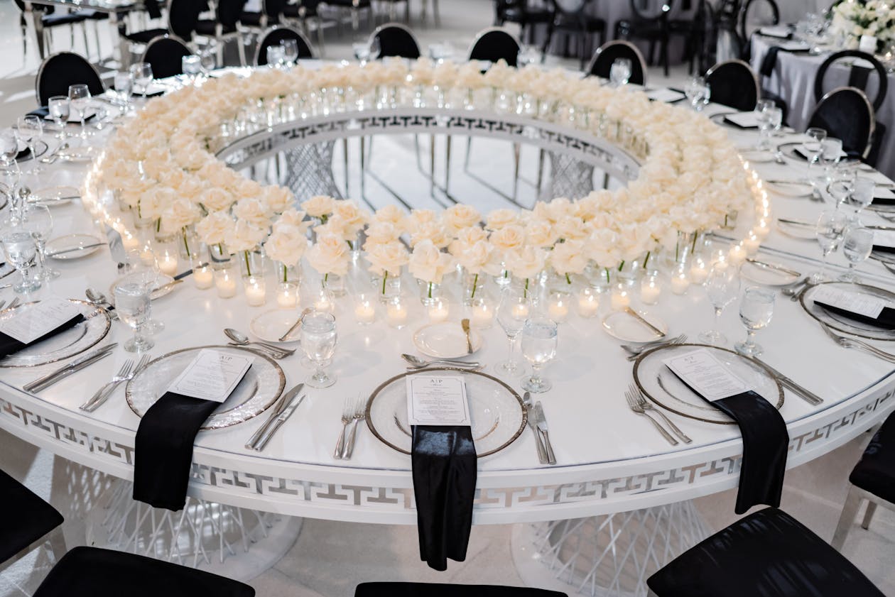 black and white wedding with circular tables with black napkins and white florals as centerpieces at each | PartySlate