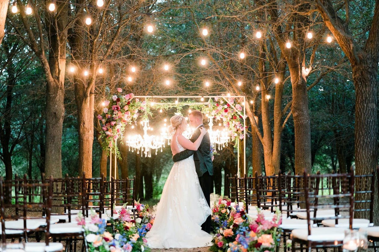 Enchanted garden wedding with string light evening ceremony | PartySlate