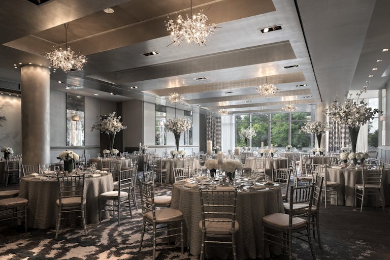 wedding in the ballroom of a boston wedding venue with silver accents and floral arrangements on tables | PartySlate