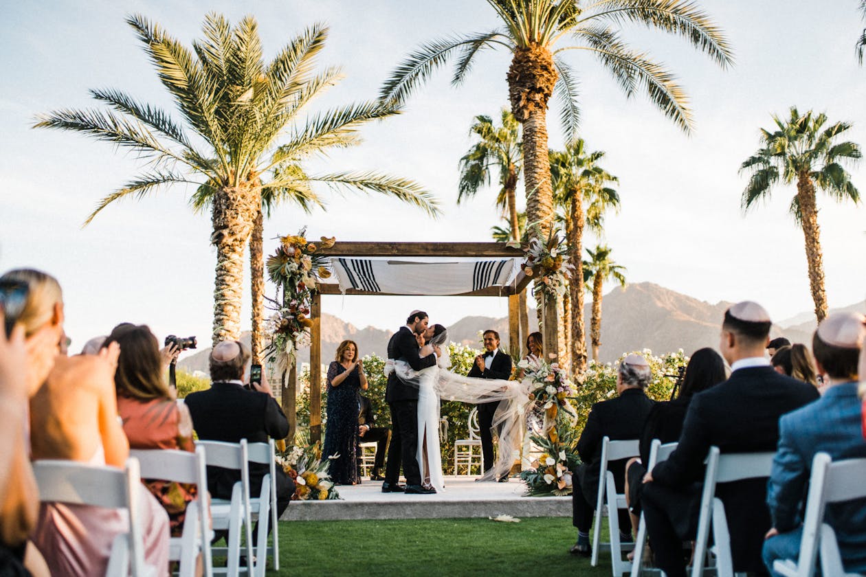 Jewish wedding ceremony with palm trees at Indian Wells Golf Resort | PartySlate