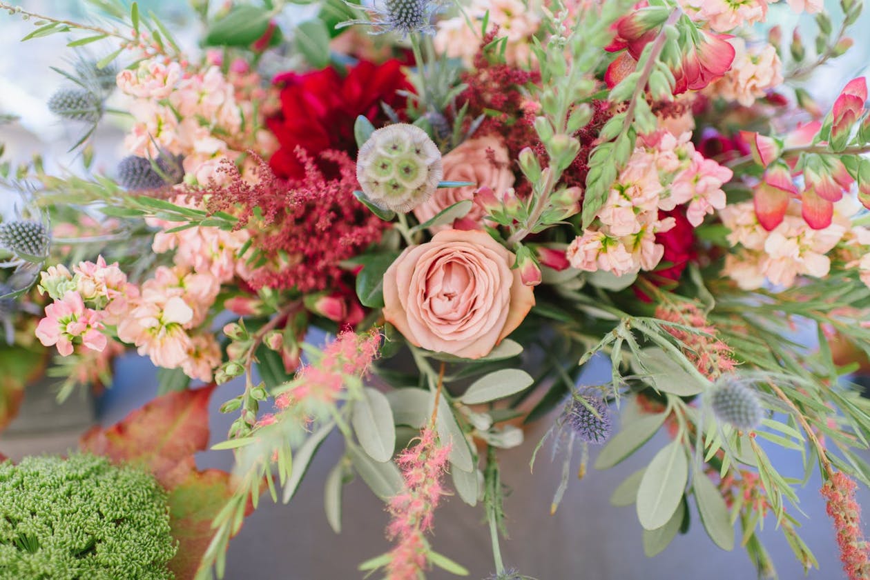 Pink and red flower centerpieces with wild grasses | PartySlate