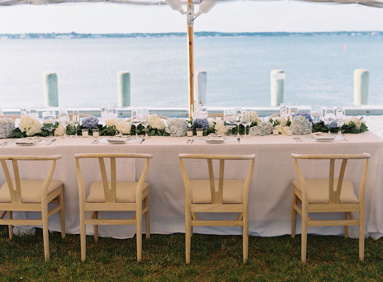 Preppy blue and white tented wedding reception on ocean | PartySlate