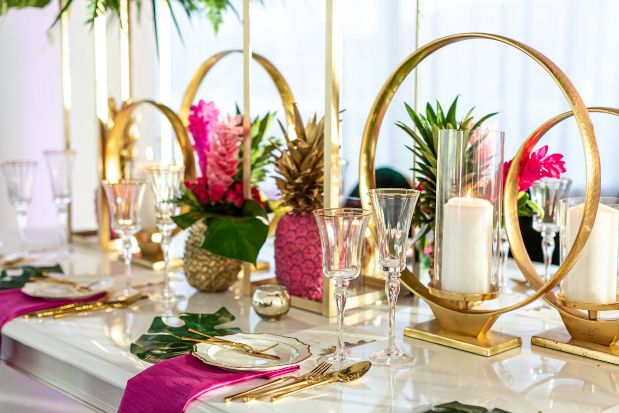 Modern wedding reception table with gold circular candle holders and pink and green pineapple décor | PartySlate