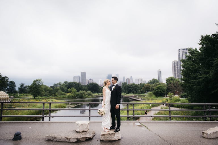 Classic wedding at Salvatore's Chicago in Lincoln Park With city skyline in the background and bride and groom posing | PartySlate