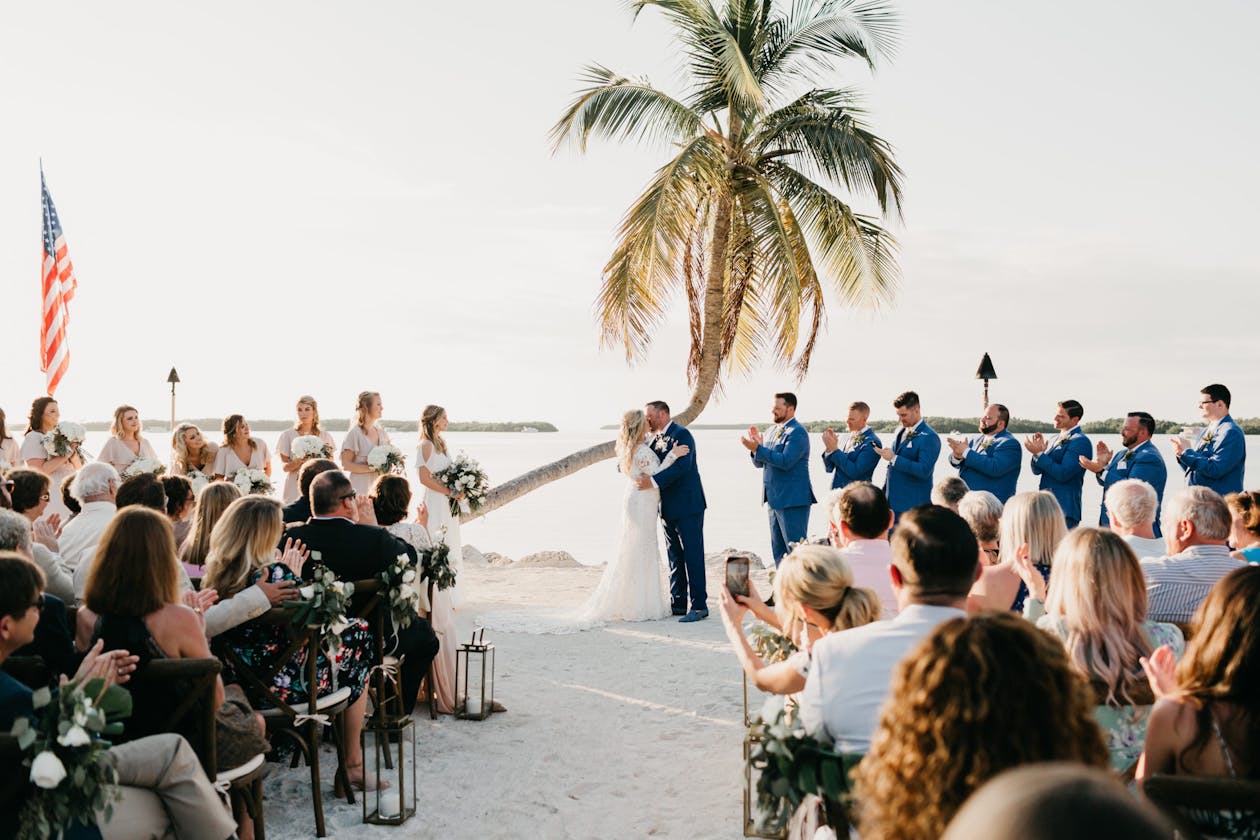 Beach wedding ceremony with palm tree backdrop | PartySlate