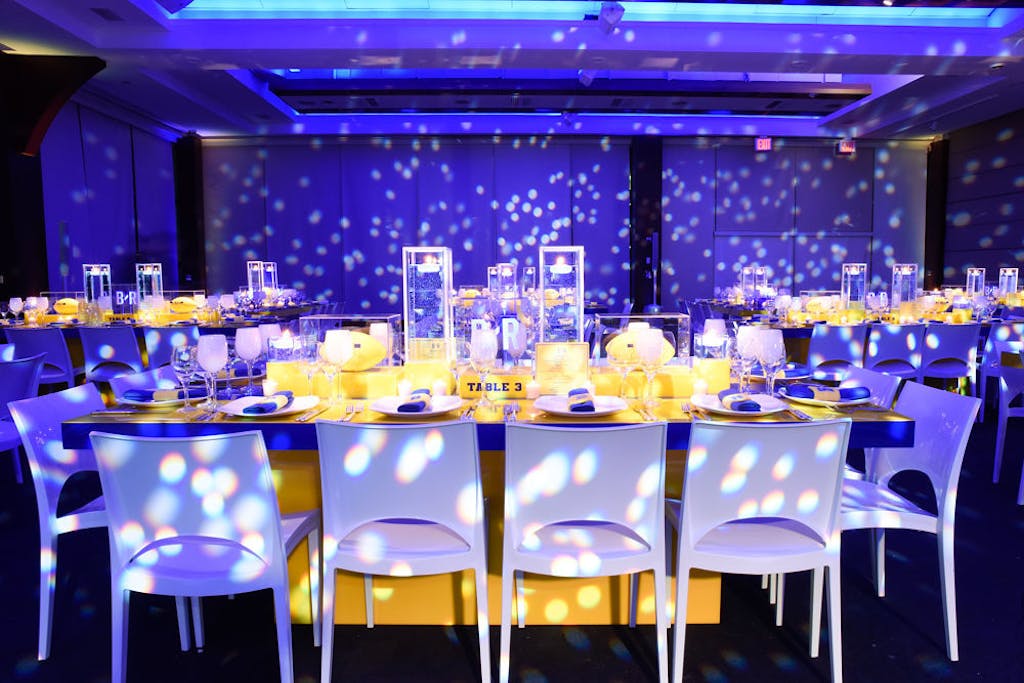 Bar Mitzvah venue transformed to tailgate theme reception with purple uplighting | PartySlate