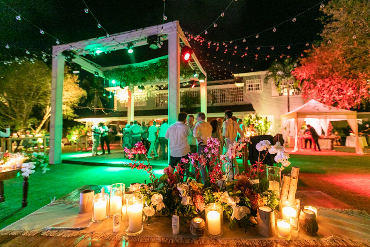 Outdoor wedding with green and orange uplighting | PartySlate