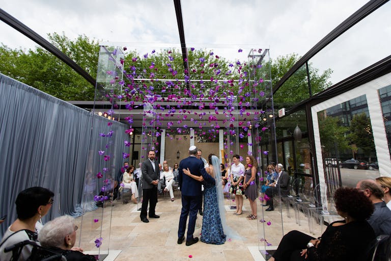 Outdoor brunch wedding with purple florals and lucite arch | PartySlate