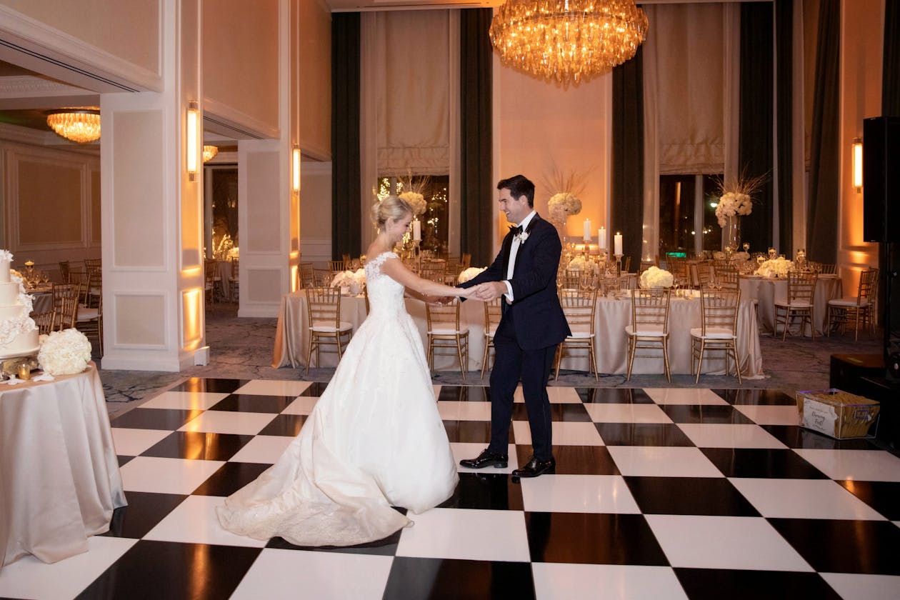 Timeless classic wedding with black and white checkered dance floor with couple dancing | PartySlate