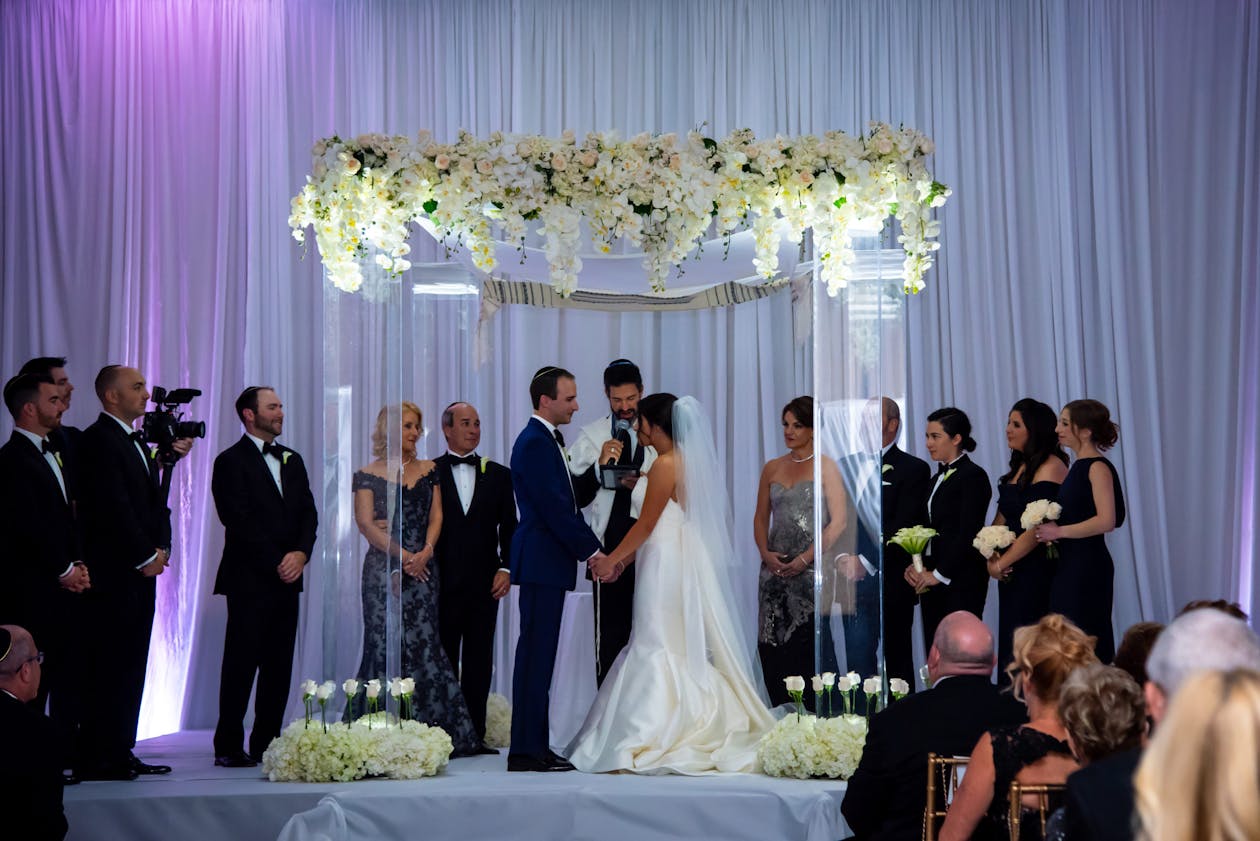 Lucite squared arch at alter with couple getting married and bridal party and groom party surrounding them | PartySlate