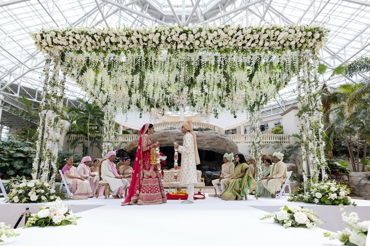 Wedding with white floral mandap | PartySlate