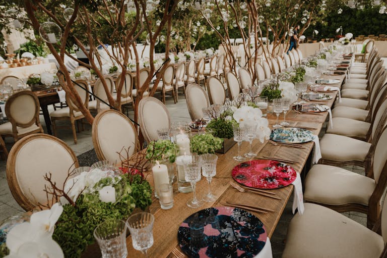 Outdoor wedding in Miami with table set and lighting hanging from trees above | PartySlate