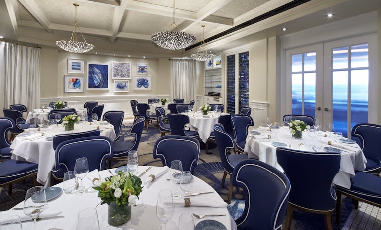 private dining dc at Fiola Mare with blue chairs and white table clothes in private dining room | PartySlate