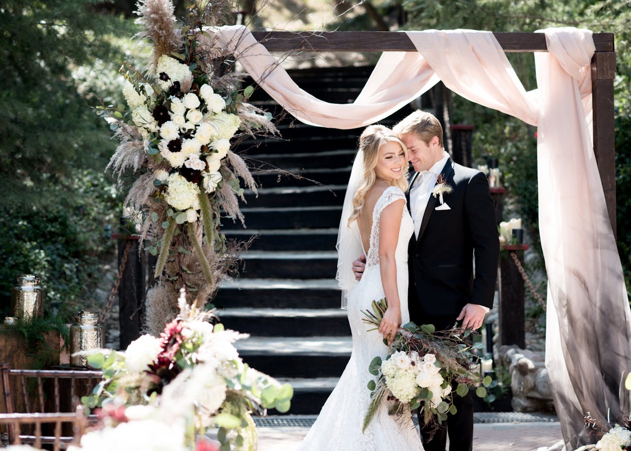 Boho moody wedding arch with pink-to-black drapery | PartySlate
