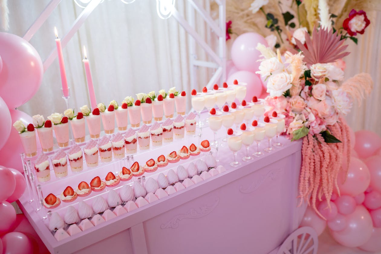pink desserts on a table displayed at baby shower | PartySlate