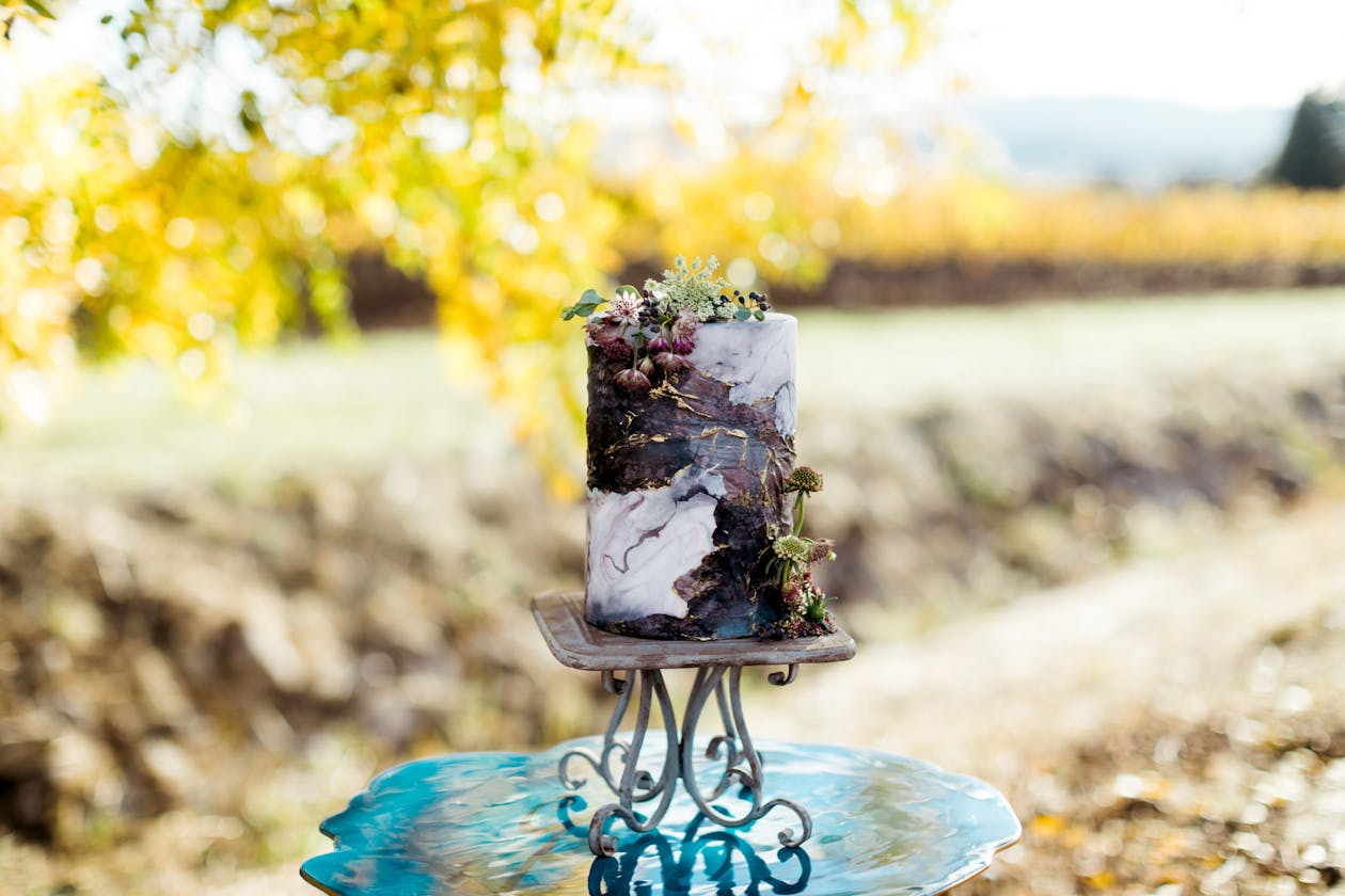Purple and white marbled wedding cake on teal table | PartySlate