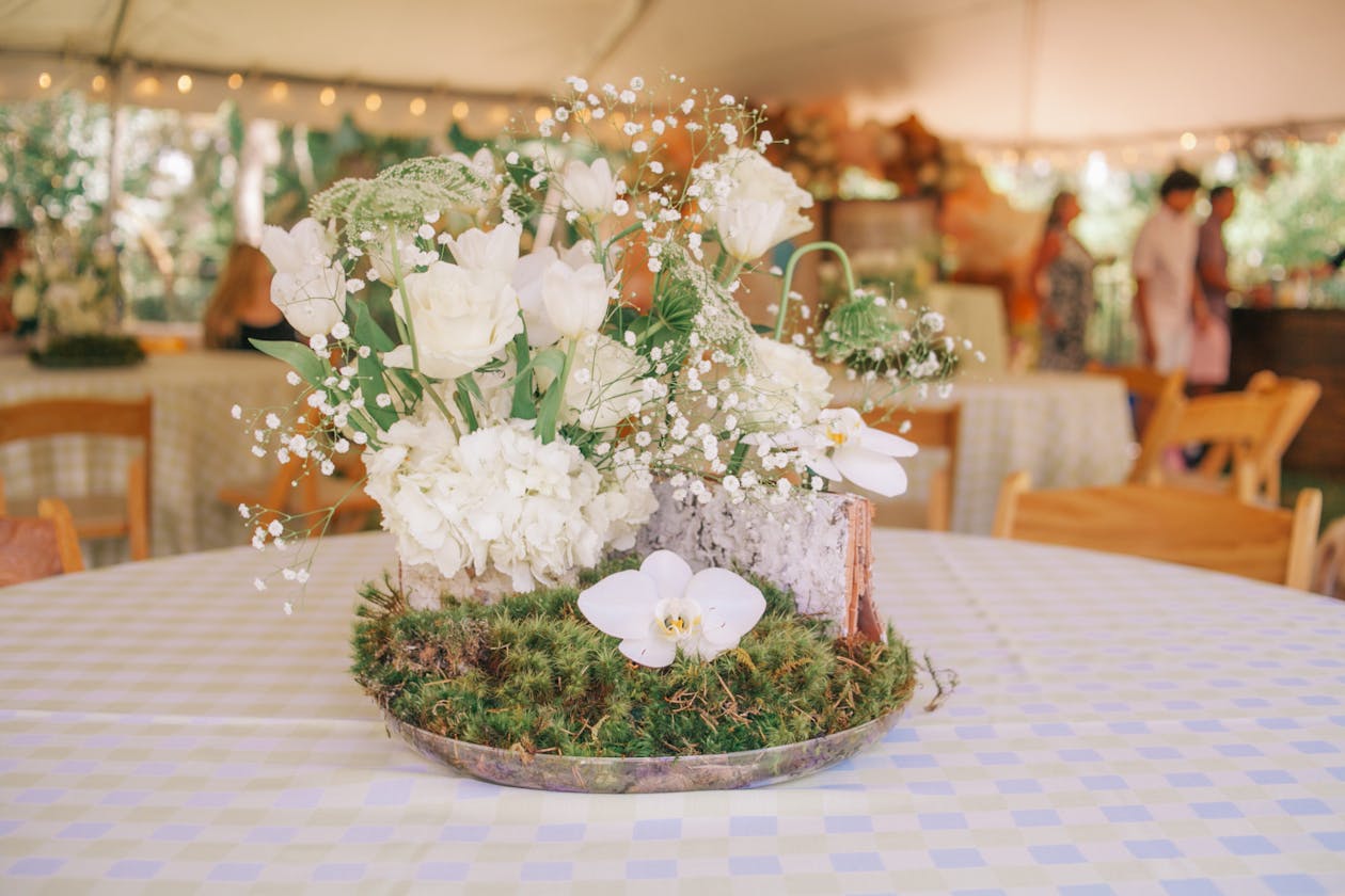 Spring baby shower centerpiece with white florals and moss | PartySlate