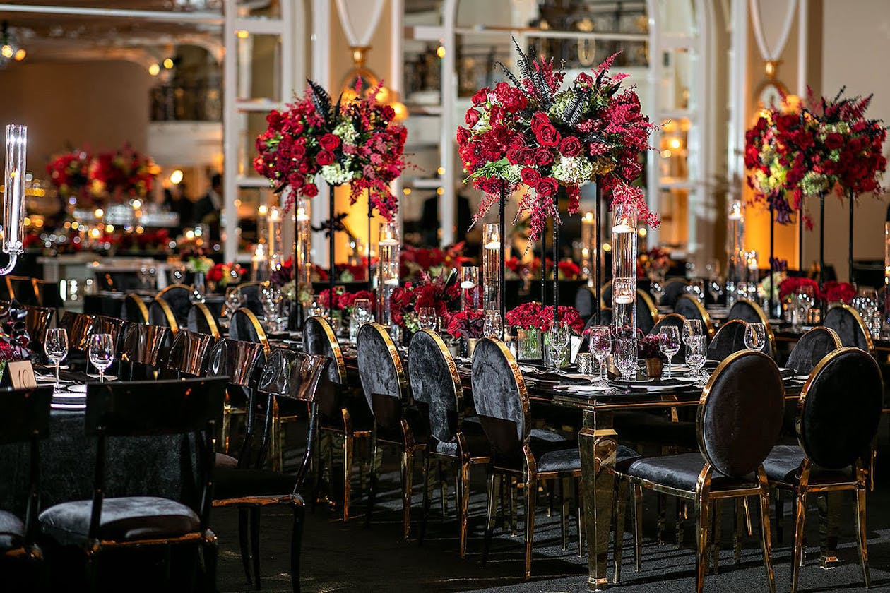 Romantic red rose wedding reception with black crushed velvet seating | PartySlate
