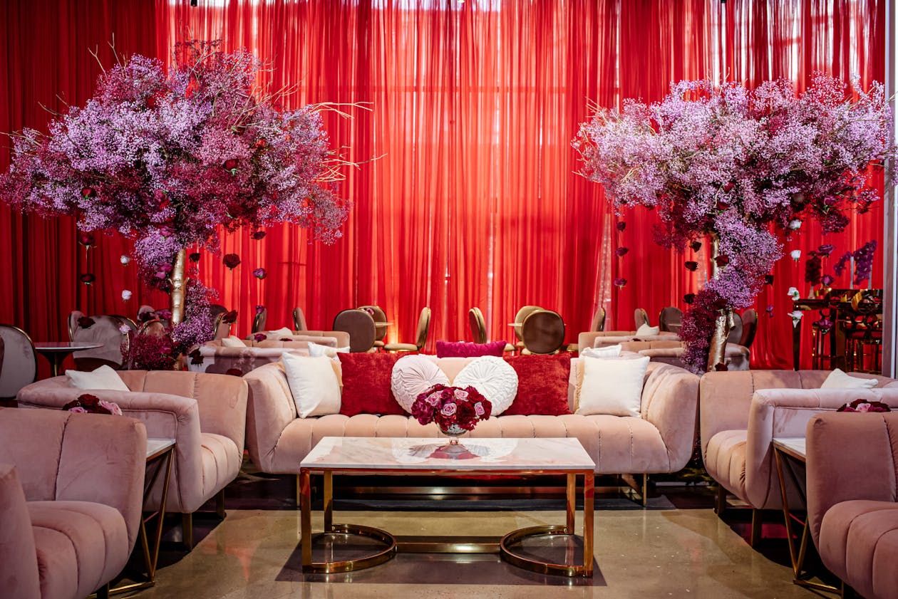 Glamorous baby shower with red curtains, pink baby's breath centerpieces, and mauve sofas | PartySlate