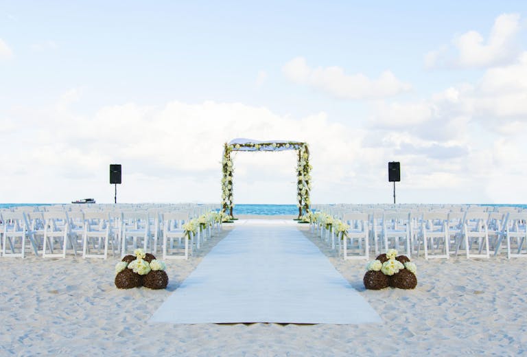 Private beach event and wedding space at the bath club miami set up with florals and wedding arch | PartySlate