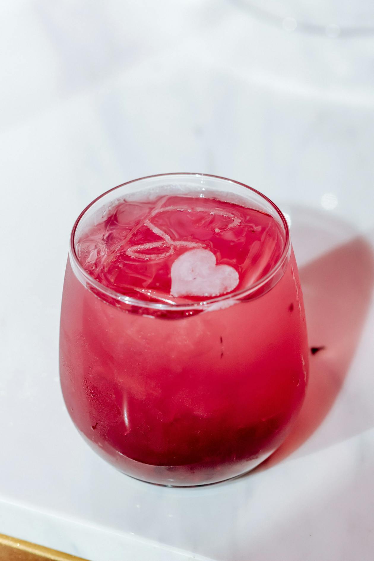 pink cocktail with engraved ice cube on top | PartySlate