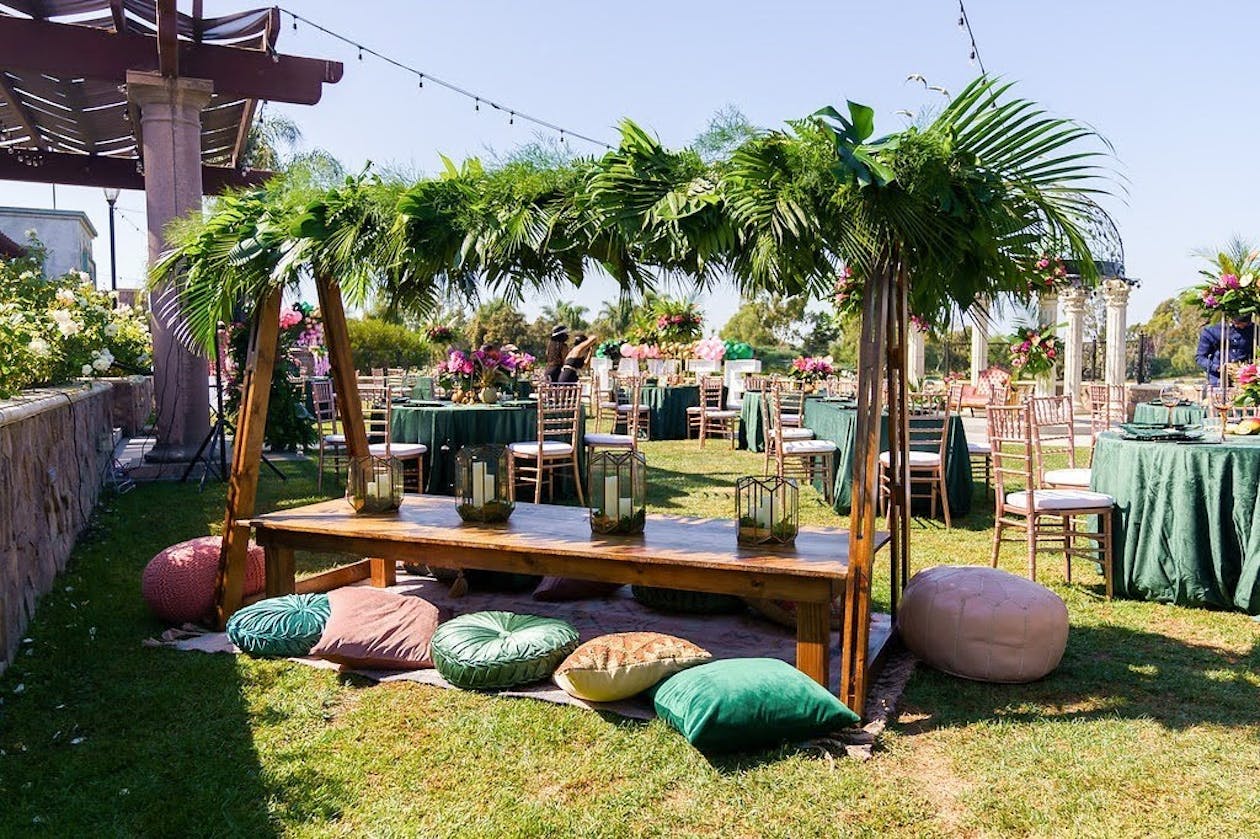Boho baby shower with elevated palm frond centerpieces | PartySlate