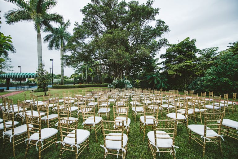outdoor wedding with chairs surrounding wedding alter | PartySlate