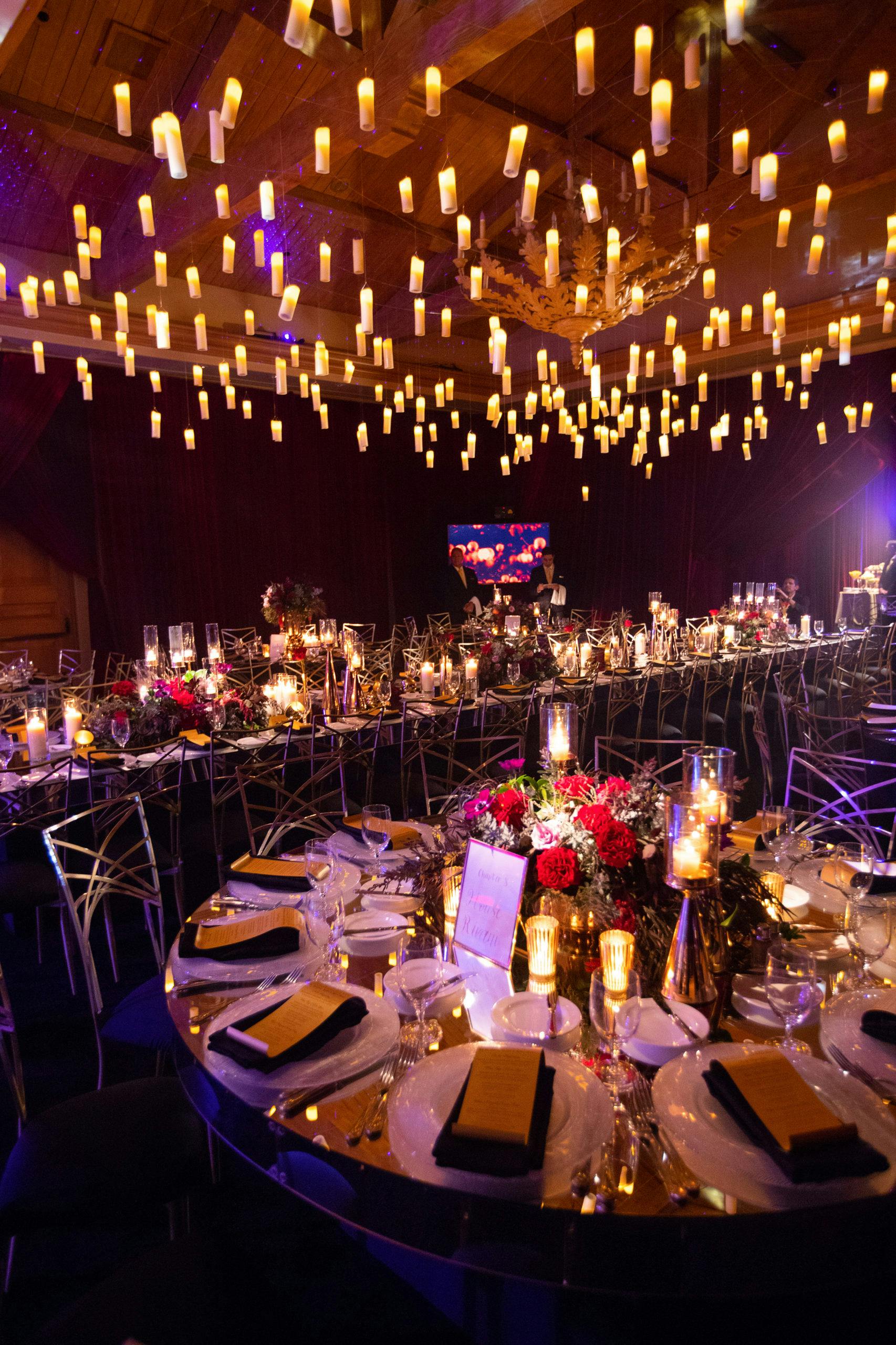 Glamorous wedding reception with suspended candle light from ceiling | PartySlate