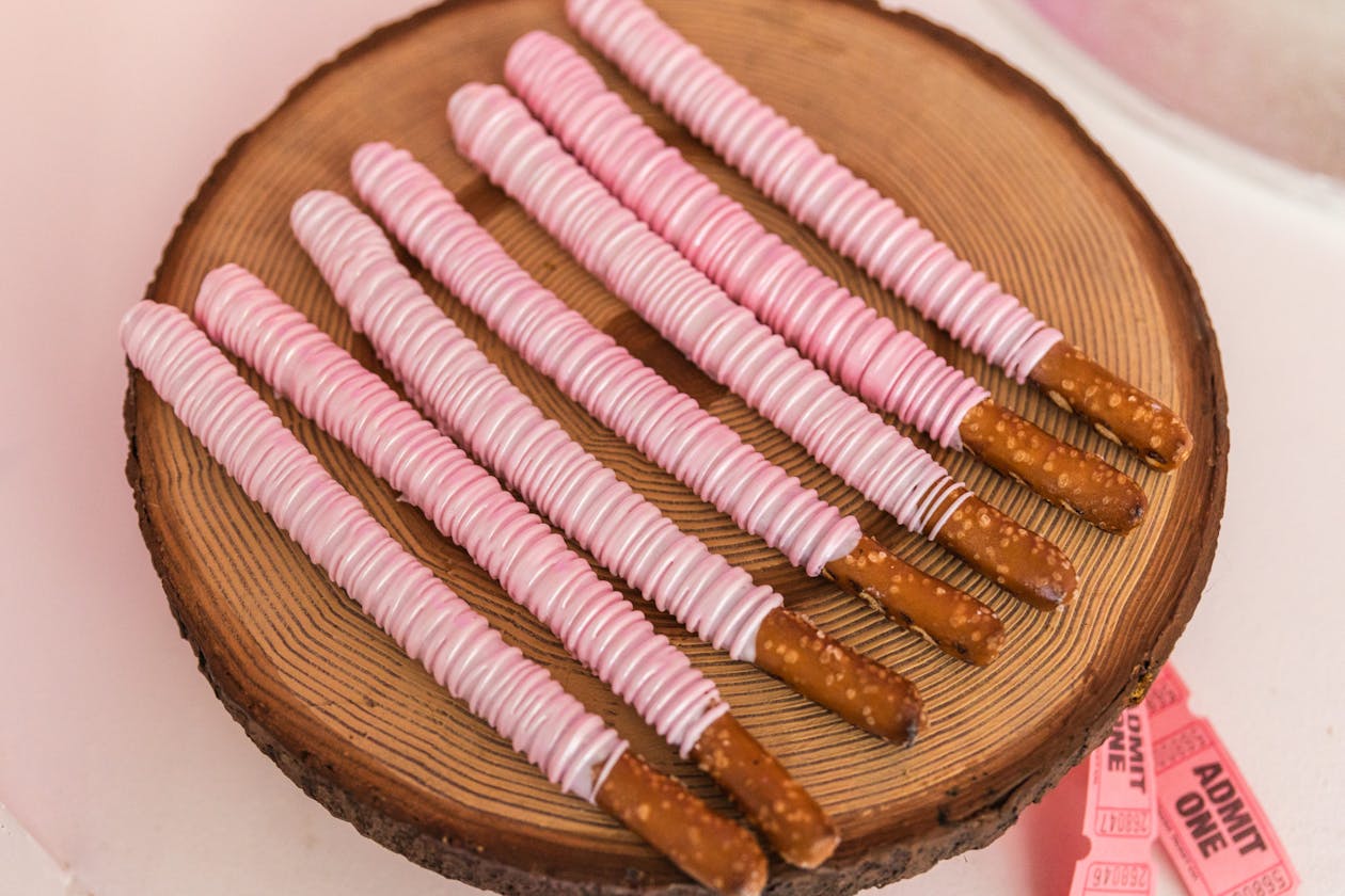 pretzel sticks covered in pink chocolate at baby shower | PartySlate