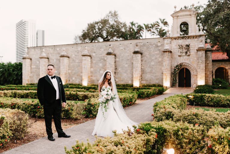 Miami wedding at The Ancient Spanish Monastery with couple standing in front of building | PartySlate