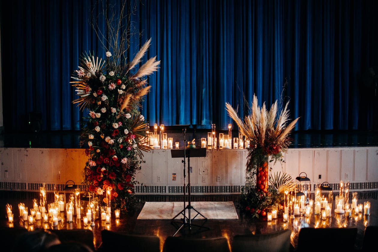 Modern wedding ceremony with blue drapery, pampas grass, and candle light | PartySlate