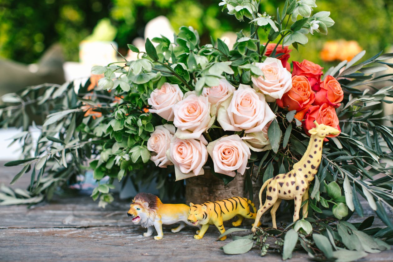 White and pink rose centerpiece with greenery and animal figurines | PartySlate