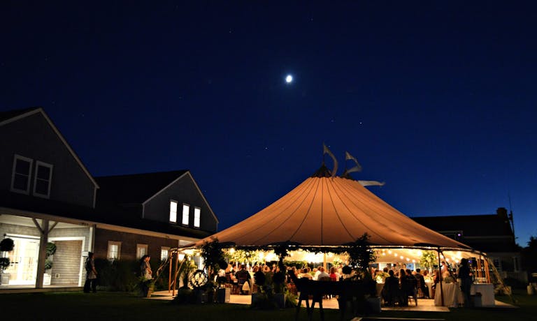 Great Harbor Yacht Club tented wedding at night | PartySlate