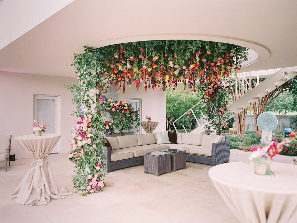 pink and green floral installation hanging from ceiling outdoor at private residence 60th birthday party | PartySlate
