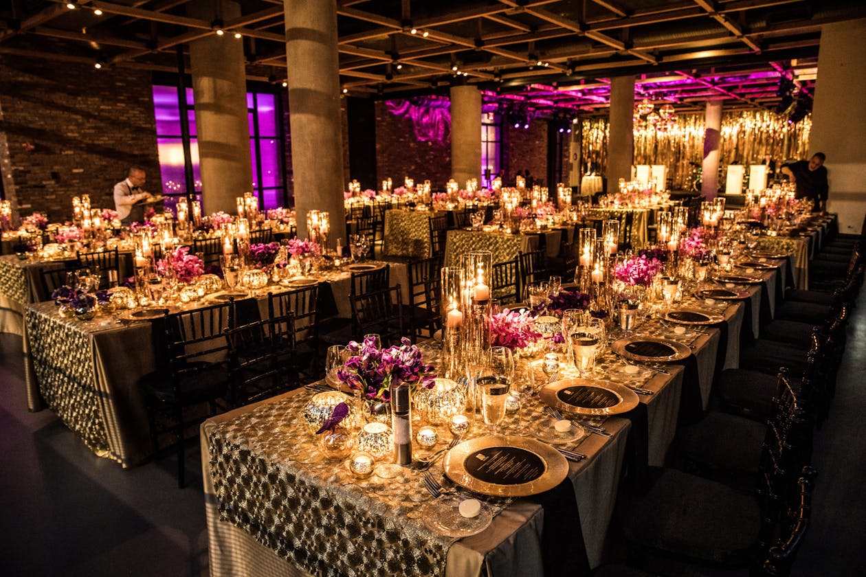 mood lighting at dinner party birthday with long rectangular tables set in room | PartySlate