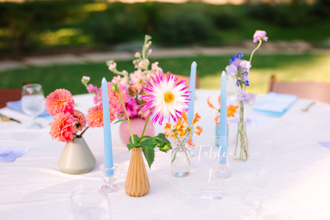 Summer wedding table with bright pink flowers and pastel blue tallow candles | PartySlate